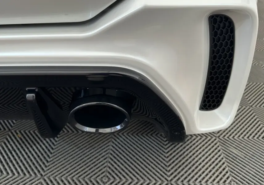 Gros plan sur l’échappement arrière droit blanc de l’AIXAM AMBITION 0.5 CITY GTO 2026 avec diffuseur noir.