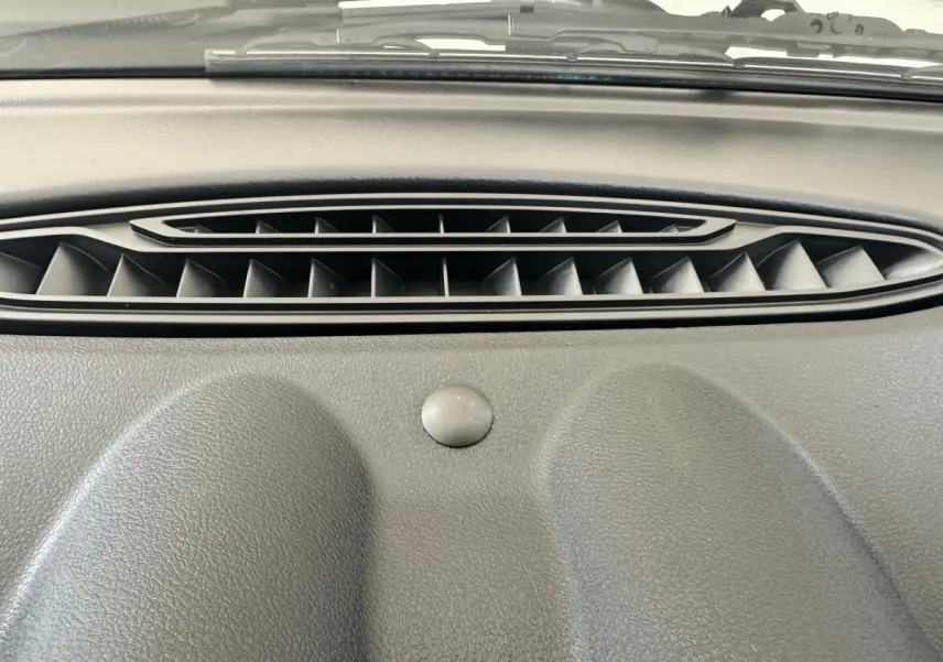 Gros plan sur la sortie d'air centrale du tableau de bord gris de l'AIXAM AMBITION 0.5 CITY GTO 2026.