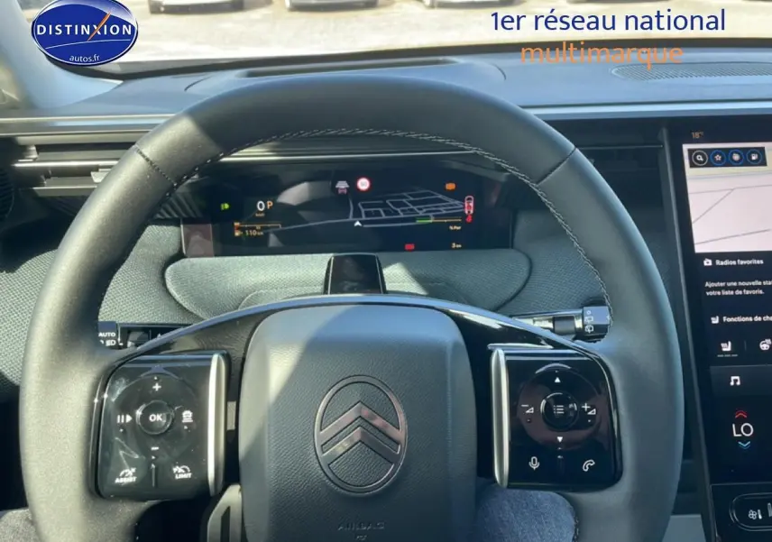 Vue intérieure centrée sur le volant noir du Citroën C5 Aircross 2026 avec tableau de bord numérique et écran tactile.