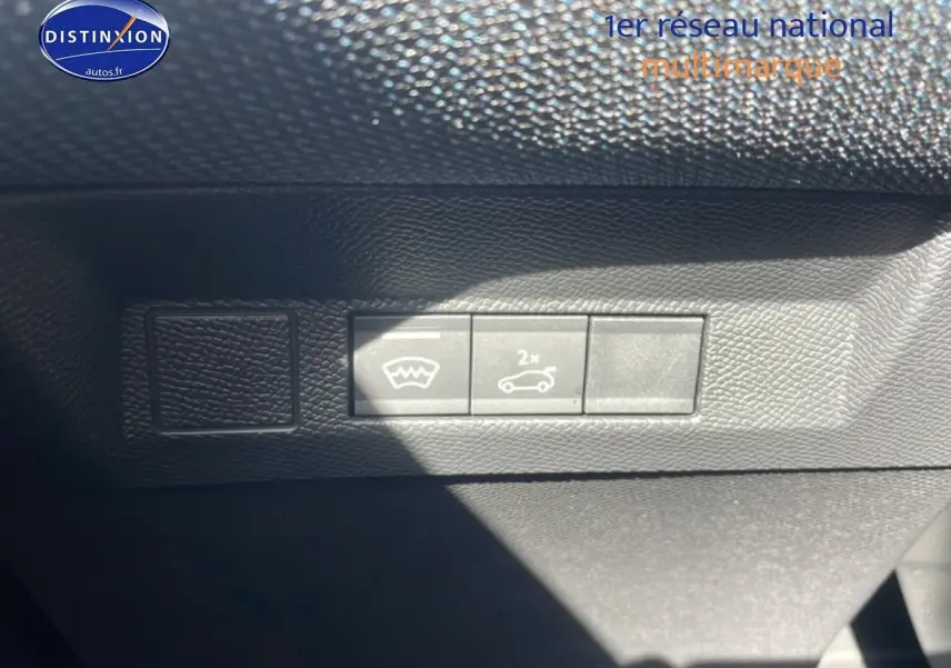 Détail intérieur montrant les boutons d'ouverture du coffre et de dégivrage sur tableau de bord noir du Citroën C5 Aircross blanc.