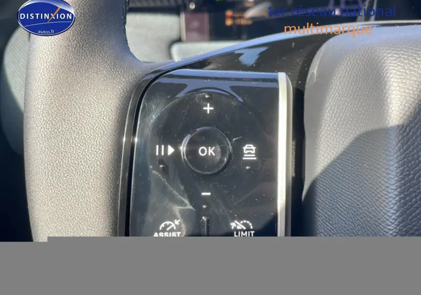 Gros plan sur les commandes au volant noir du Citroën C5 Aircross blanc, avec boutons multifonctions et régulateur de vitesse.