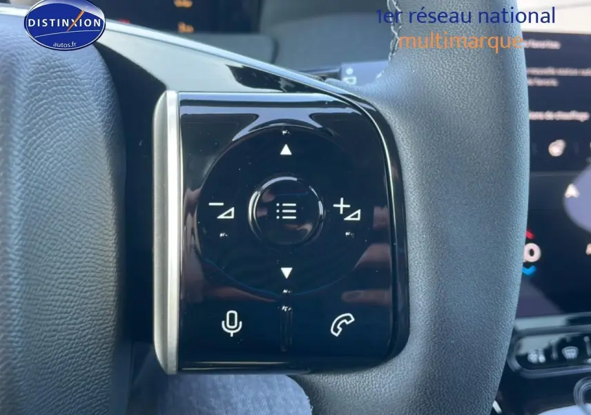 Gros plan sur les commandes noires du volant du Citroën C5 Aircross hybride blanc, avec touches multifonctions.