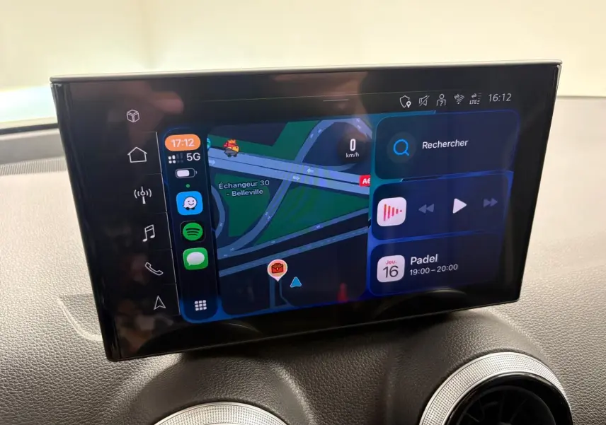 Écran tactile central de l'Audi Q2 35 TFSI 2026 affichant la navigation et les applications, intérieur noir.