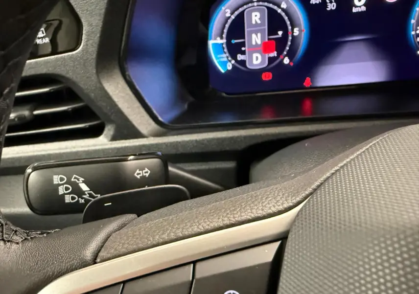 Gros plan sur le tableau de bord digital et le volant cuir du Volkswagen Caddy 2.0 TDI 122 DSG7 Business.