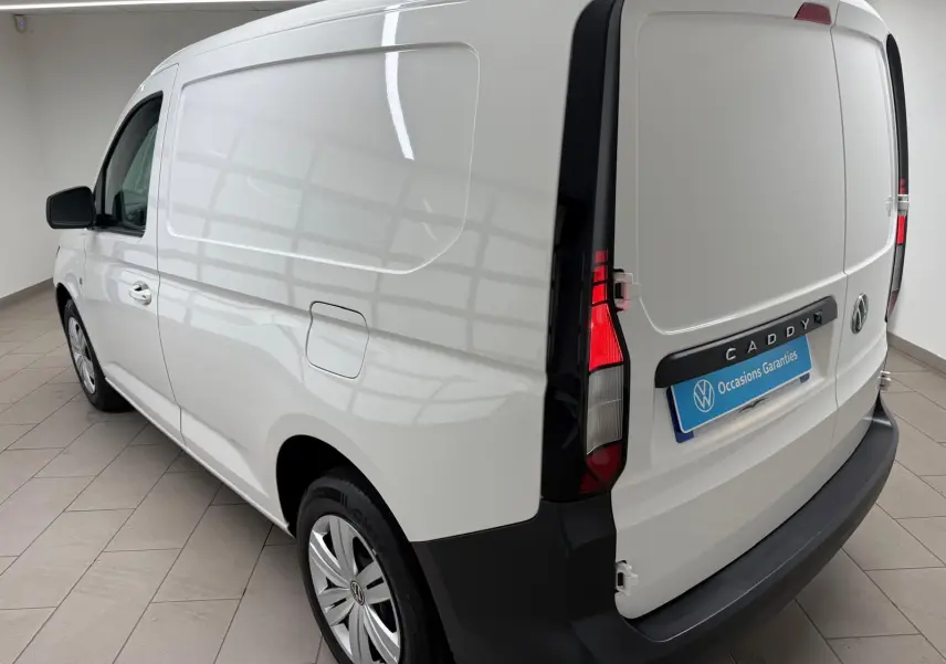 Vue 3/4 arrière droite du Volkswagen Caddy blanc Candy, avec feux arrière verticaux et pare-chocs noir mat.
