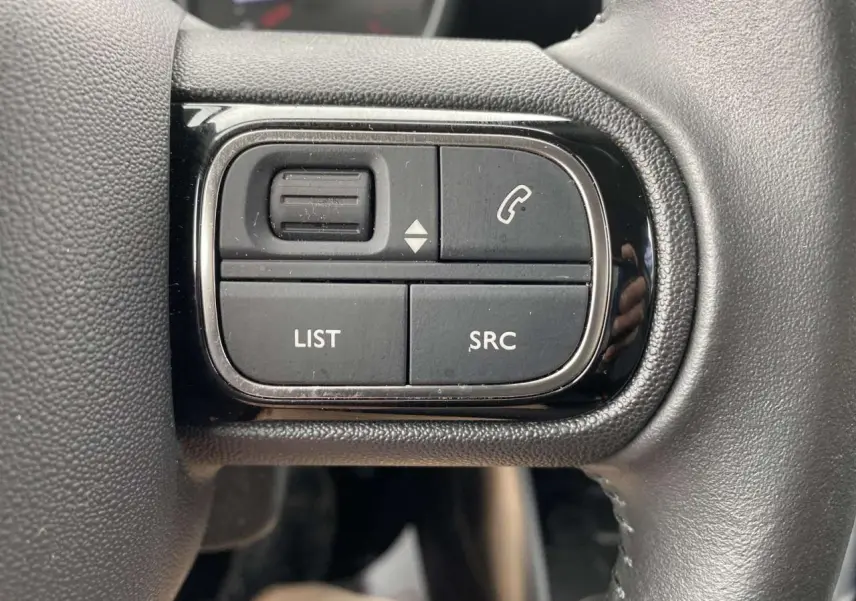 Détail des commandes noires sur le volant du Citroën C3 Aircross 2020, version grise essence, vue rapprochée.
