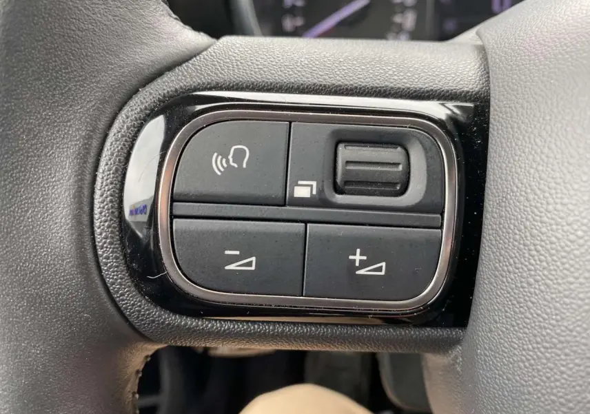 Gros plan sur les commandes vocales et volume au volant d’un Citroën C3 Aircross 2020, finition Shine.