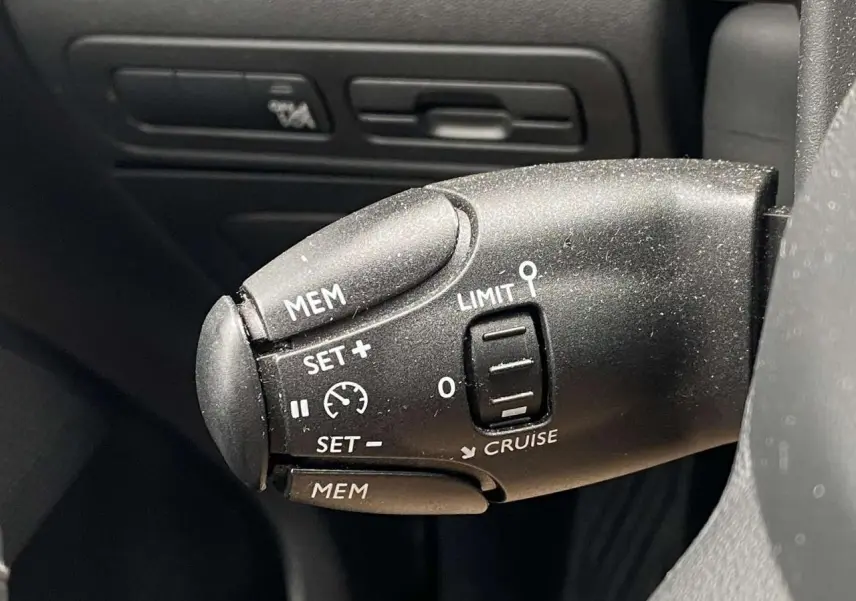 Gros plan sur la commande de régulateur de vitesse du Citroën C3 Aircross 2020, finition Shine, intérieur noir.