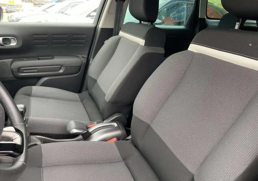 Vue intérieure côté gauche des sièges avant gris du Citroën C3 Aircross 2020 avec détails tissu et accoudoir central.