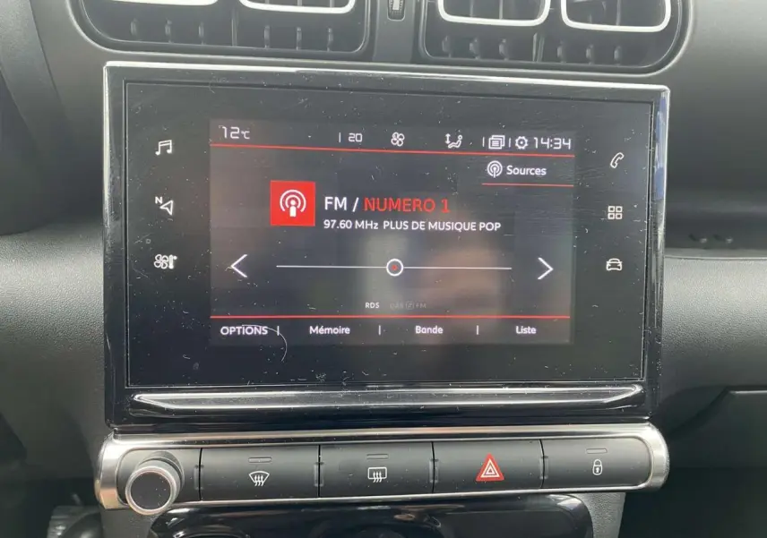 Vue rapprochée de l’écran tactile central du Citroën C3 Aircross 2020 gris, affichant une station radio FM.