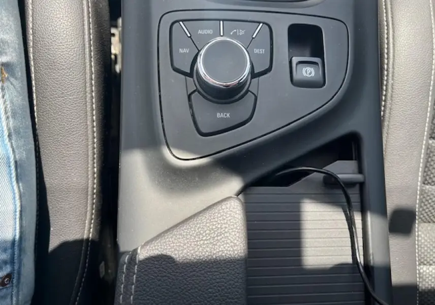 Vue rapprochée de la console centrale de l'Opel Insignia Sports Tourer 2011, avec commande multimédia et frein de parking électrique.
