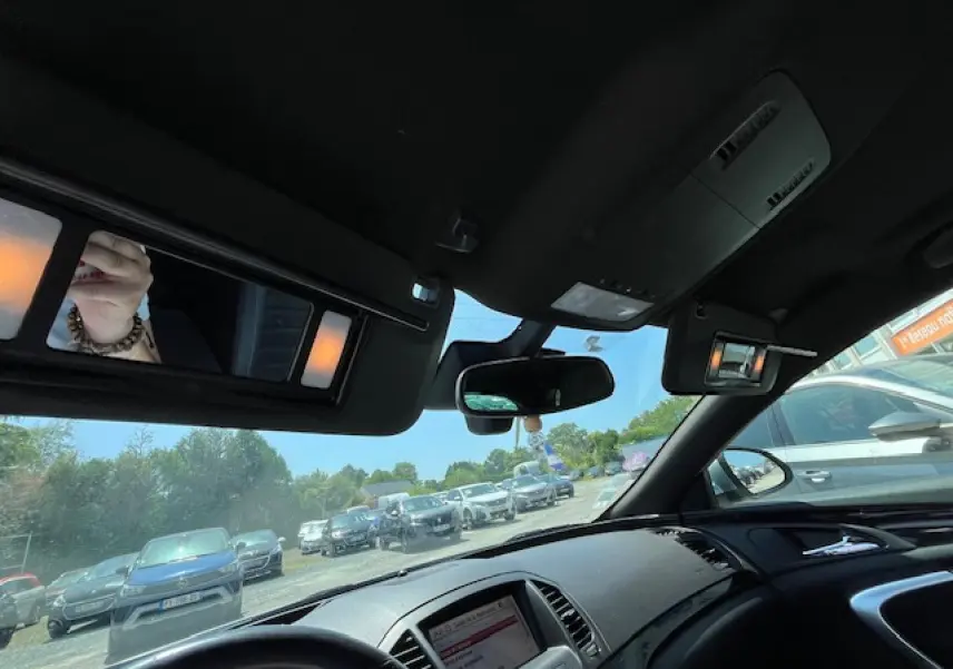 Vue intérieure avant droite de l’Opel Insignia Sports Tourer gris clair, avec tableau de bord et rétroviseur central visibles.