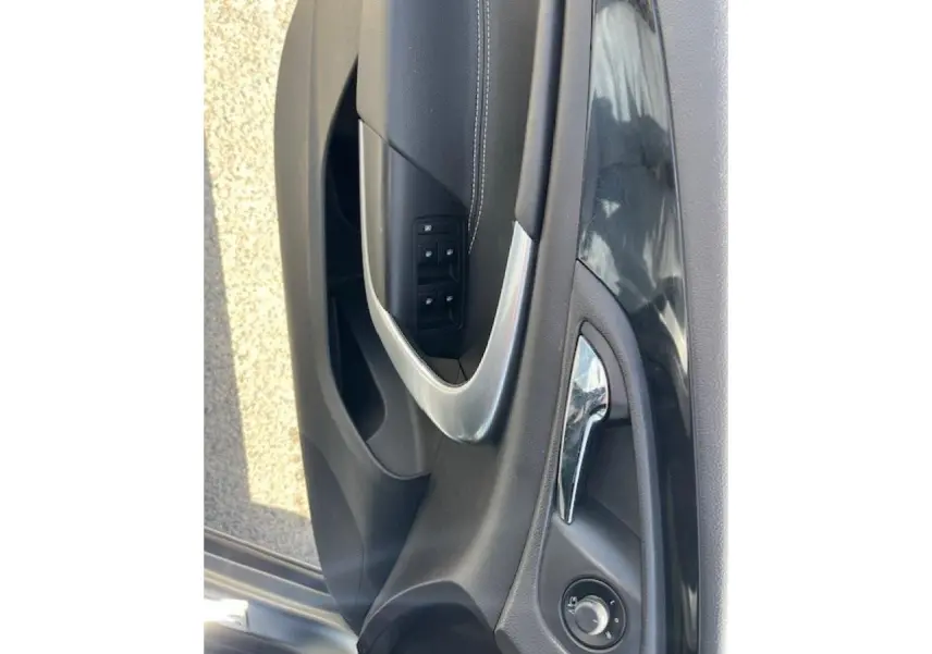 Gros plan sur la porte avant gauche de l’Opel Insignia Sports Tourer gris clair, avec poignée et commandes électriques.