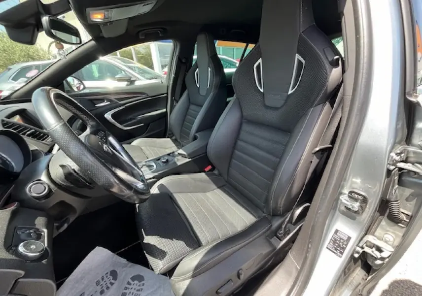Vue intérieure côté conducteur de l’Opel Insignia Sports Tourer gris clair, sièges sport en cuir et alcantara avec finitions argentées.