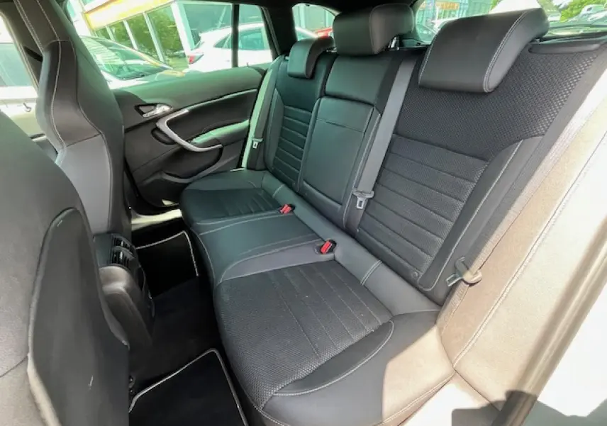 Vue intérieure arrière droite des sièges en cuir noir de l’Opel Insignia Sports Tourer gris clair de 2011.