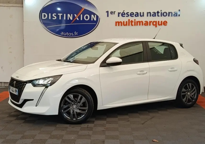 Peugeot 208 blanc vue de profil côté gauche, avec feux LED et jantes alliage sombres en intérieur showroom.