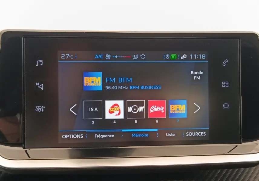 Écran tactile central de la Peugeot 208 blanc affichant les stations radio FM avec interface moderne et icônes colorées.