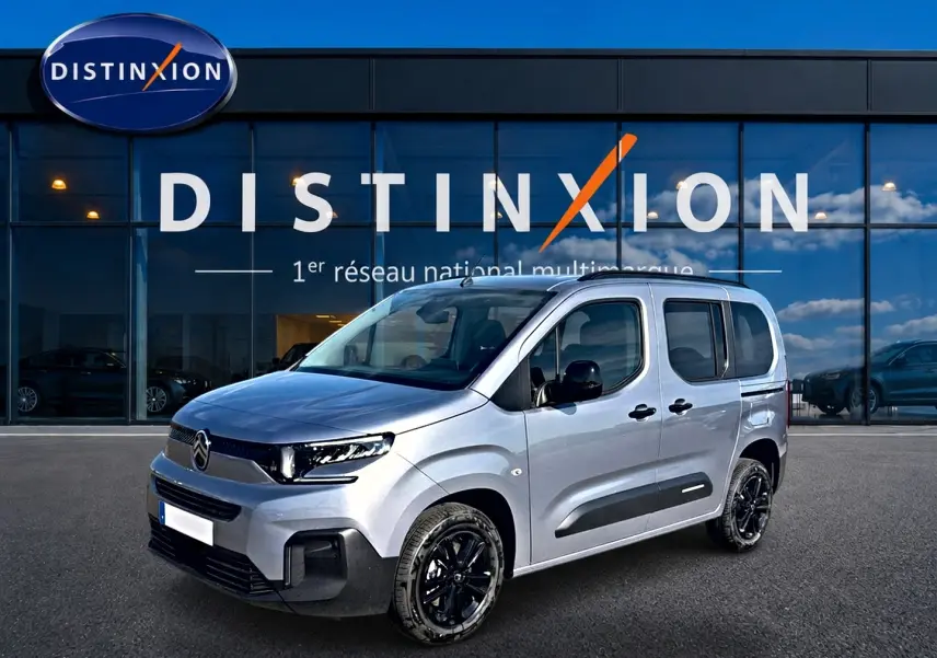 Vue 3/4 avant droit du Citroën Berlingo 2026 gris acier avec jantes noires et protections latérales noires.