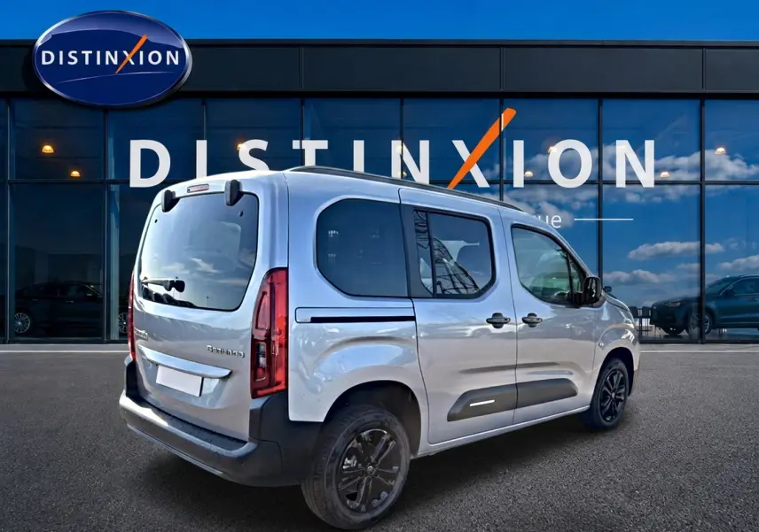 Vue 3/4 arrière droite d’un Citroën Berlingo Steel Grey 2026 avec jantes alu noires et barres de toit.