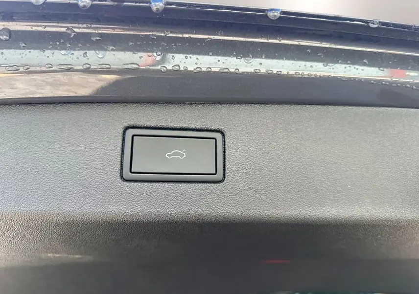 Bouton d'ouverture électrique du coffre sur le bord intérieur gris dauphin du Volkswagen Tiguan 2024.