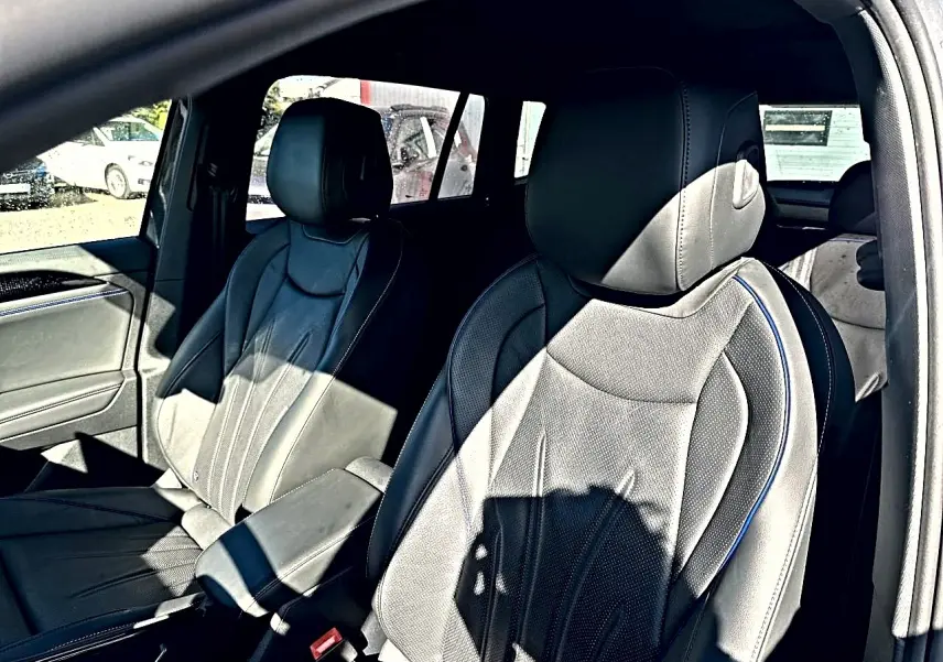 Vue intérieure des sièges avant en cuir noir Vienna avec surpiqûres bleues du Volkswagen Tiguan 2024 gris dauphin.