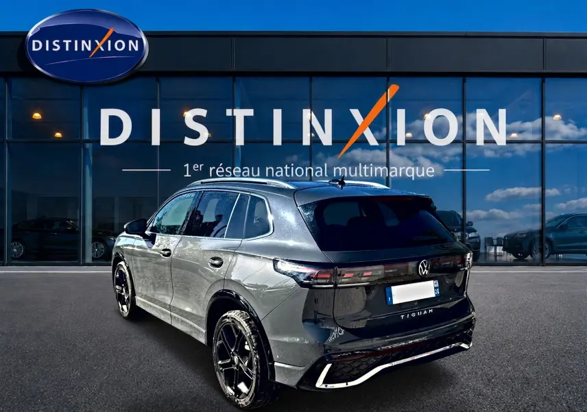 Volkswagen Tiguan 2024 gris dauphin en 3/4 arrière droit, avec jantes noires et détails R-Line noirs brillants.