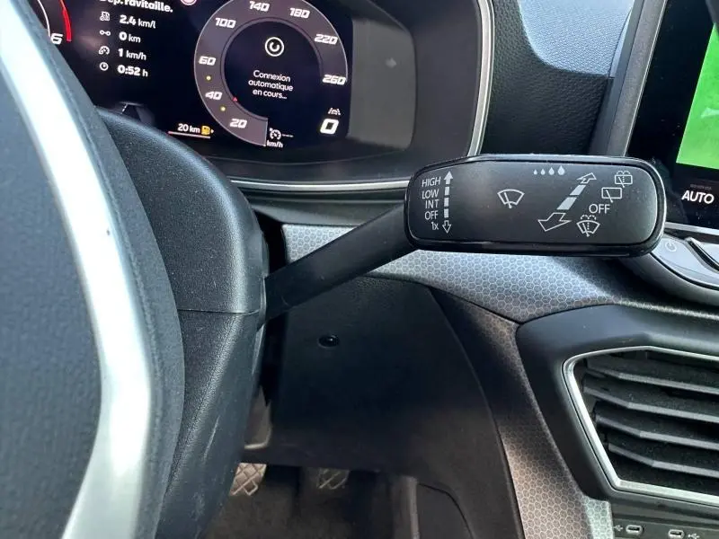 Gros plan sur la commande d'essuie-glace à gauche du volant dans l'habitacle gris du SEAT LEON ST 2025.