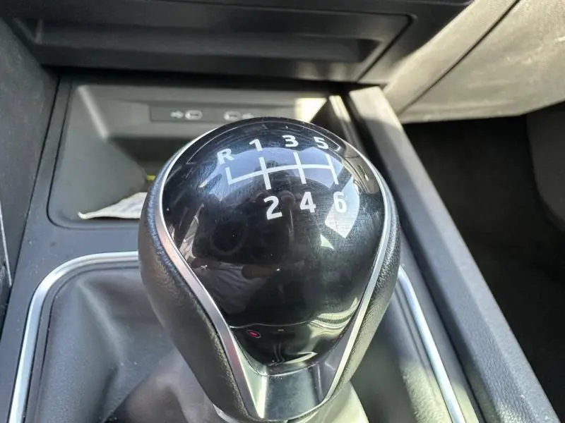 Gros plan sur le levier de vitesses manuel noir brillant du SEAT LEON ST 2.0 TDI 115ch STYLE XL, intérieur gris.