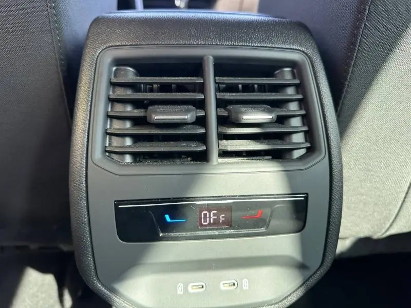 Vue rapprochée des aérateurs arrière et commandes de climatisation avec affichage digital du SEAT LEON ST 2025 gris métallisé.