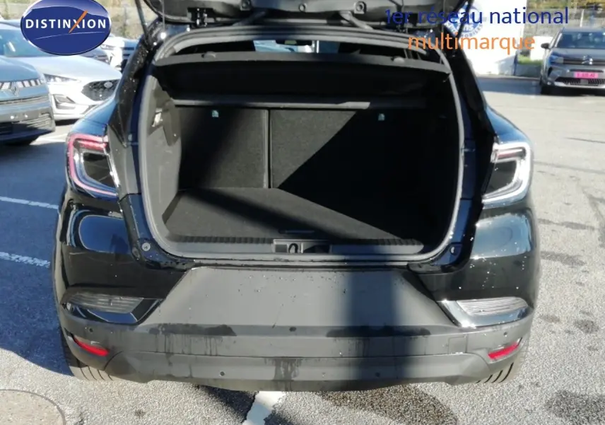 Vue arrière d'un Renault Captur noir étoile métal 2026 avec coffre ouvert sur un parking extérieur.