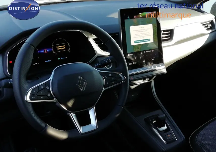 Vue intérieure du poste de conduite du Renault Captur E-Tech, avec volant multifonction et écran tactile vertical.