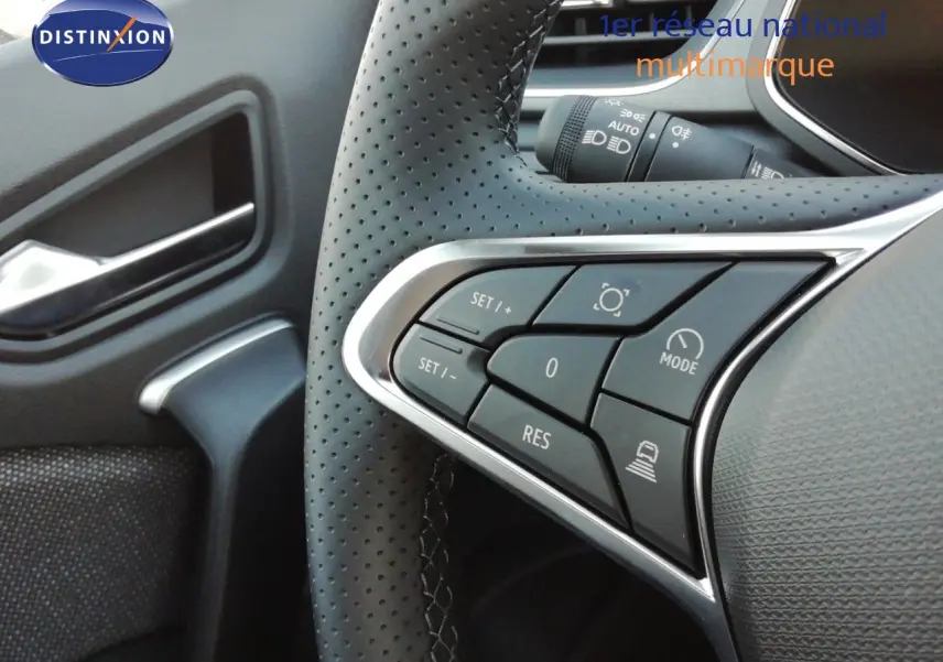Gros plan sur les commandes au volant en cuir perforé noir du Renault Captur E-Tech 2026, avec détails chromés.