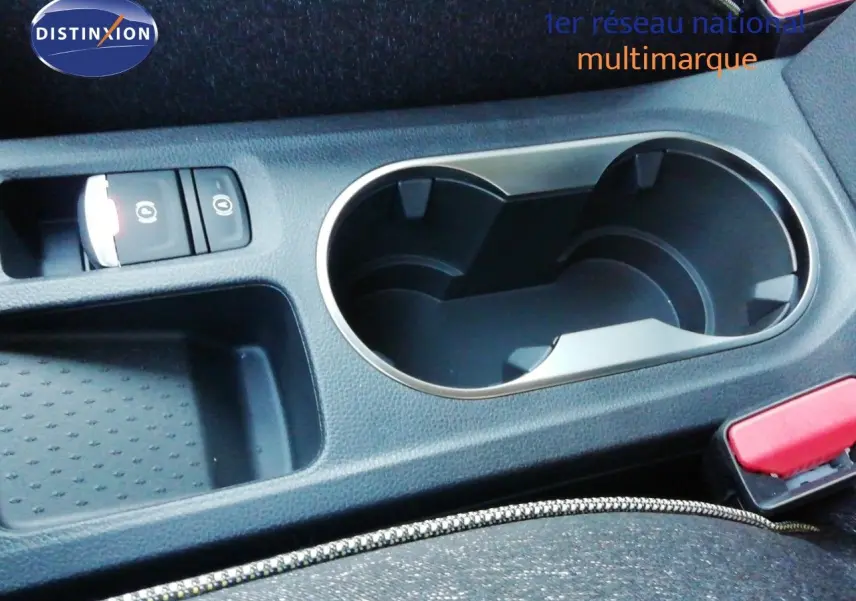 Gros plan sur la console centrale du Renault Captur 2026 noir étoile métal, avec porte-gobelets et bouton frein à main électrique.