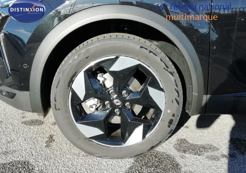 Gros plan sur la roue avant gauche du Renault Captur noir étoile métal, mettant en valeur la jante bi-ton distinctive.