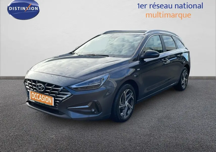 Hyundai i30 SW 2024 gris Dark Knight Metal vue 3/4 avant droit avec calandre distinctive et jantes alliage.