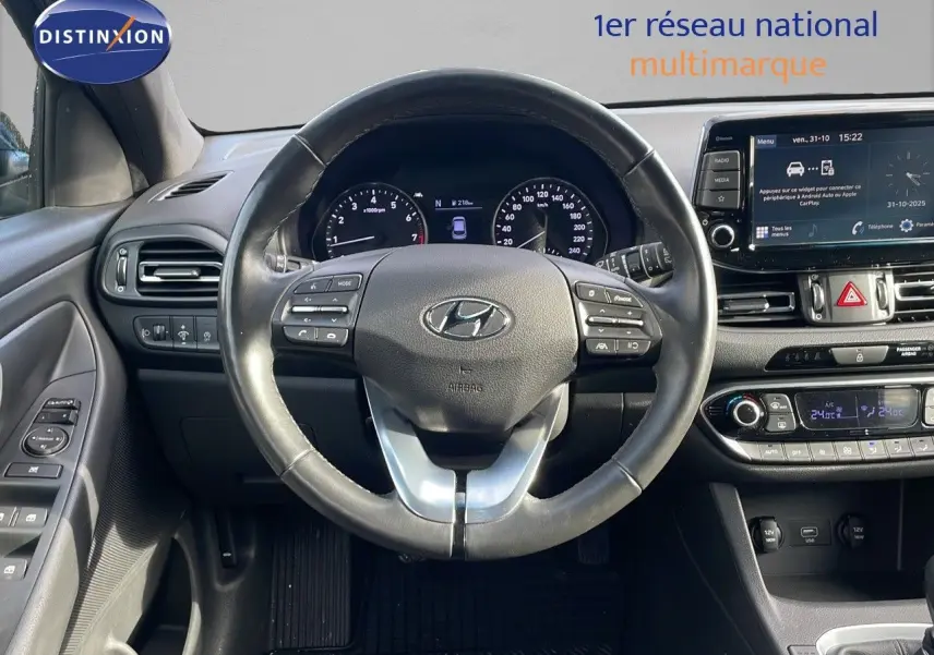 Vue intérieure centrée sur le volant et tableau de bord de la Hyundai i30 SW 2024, finition PLAY, avec écran tactile et commandes au volant.
