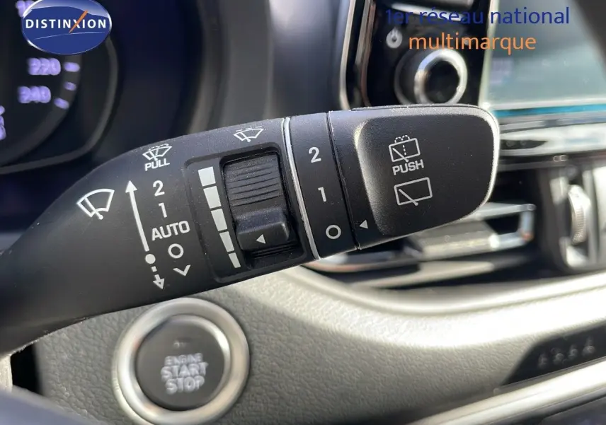 Gros plan sur la commande des essuie-glaces et le bouton start/stop dans l'habitacle d'une Hyundai i30 SW gris foncé.