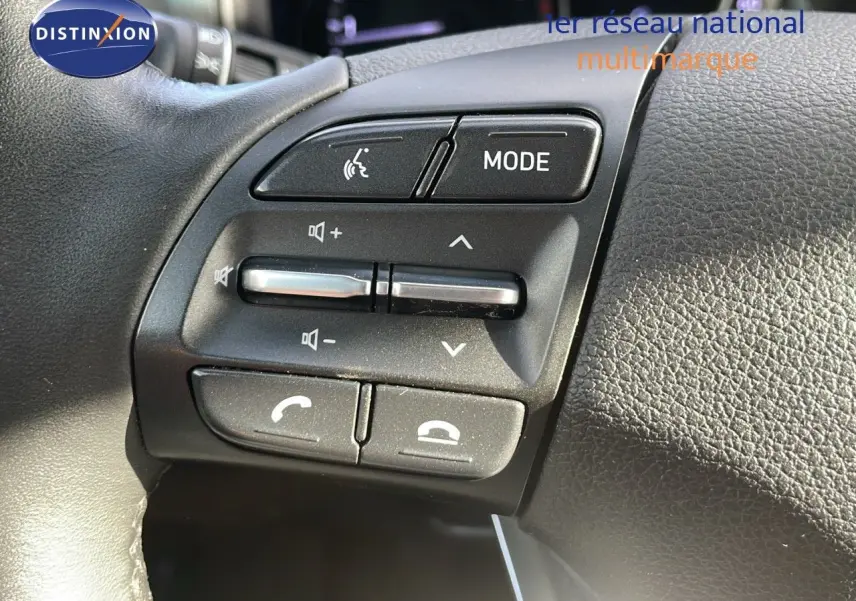 Gros plan sur les commandes audio et téléphone au volant de la Hyundai i30 SW 2024 finition Play en cuir noir.