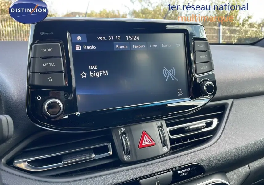 Tableau de bord de Hyundai i30 SW 2024 avec écran tactile radio et commandes centrales en vue rapprochée.