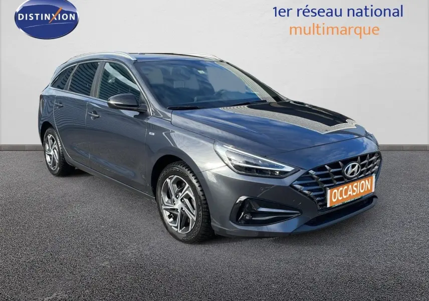 Hyundai i30 SW 2024 gris Dark Knight Metal vue 3/4 avant droit avec calandre distinctive et jantes alliage.