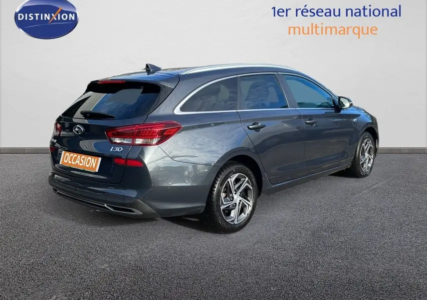 Vue 3/4 arrière droite d'une Hyundai i30 SW 2024 gris foncé Dark Knight Metal avec jantes alliage et feux LED.