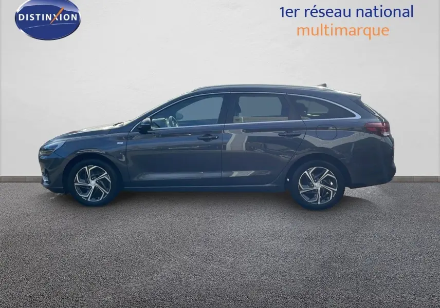 Profil latéral droit d'une Hyundai i30 SW 2024 en couleur Dark Knight Metal, avec jantes alliage et lignes élégantes.