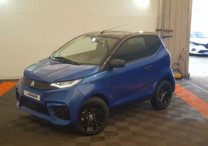 Vue 3/4 avant droite de l'AIXAM AMBITION 0.5 CITY SPORT bleu 2026 avec jantes noires et toit noir.