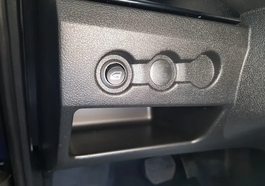 Gros plan sur le bouton d'ouverture du coffre dans l'habitacle de l'AIXAM AMBITION 0.5 CITY SPORT 2026 bleu.