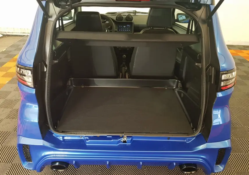 Vue arrière ouverte de l'AIXAM AMBITION 0.5 CITY SPORT bleu 2026, montrant le coffre vide et l'intérieur des sièges avant.