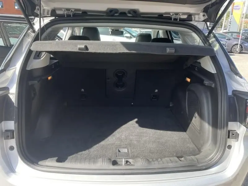 Coffre ouvert vu de l'arrière d'un Jeep Compass gris métal 2023, montrant l'espace de chargement et la plage arrière relevée.