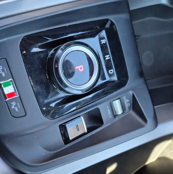 Vue rapprochée de la molette de sélection de vitesse et commandes centrales noires de l'Alfa Romeo Tonale bleu 2025.