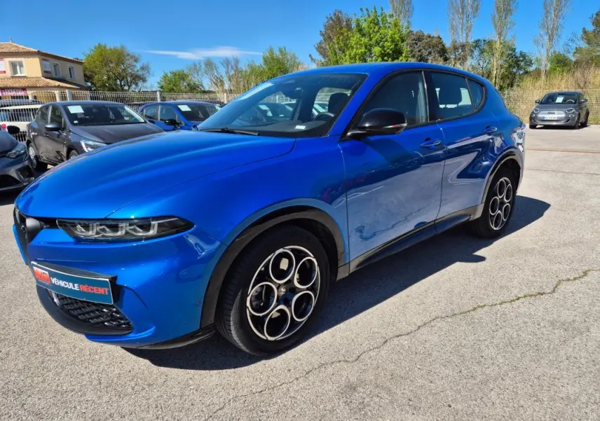 Vue 3/4 avant droite d'un Alfa Romeo Tonale bleu avec jantes alliage 18 pouces et rétroviseurs noirs brillants.
