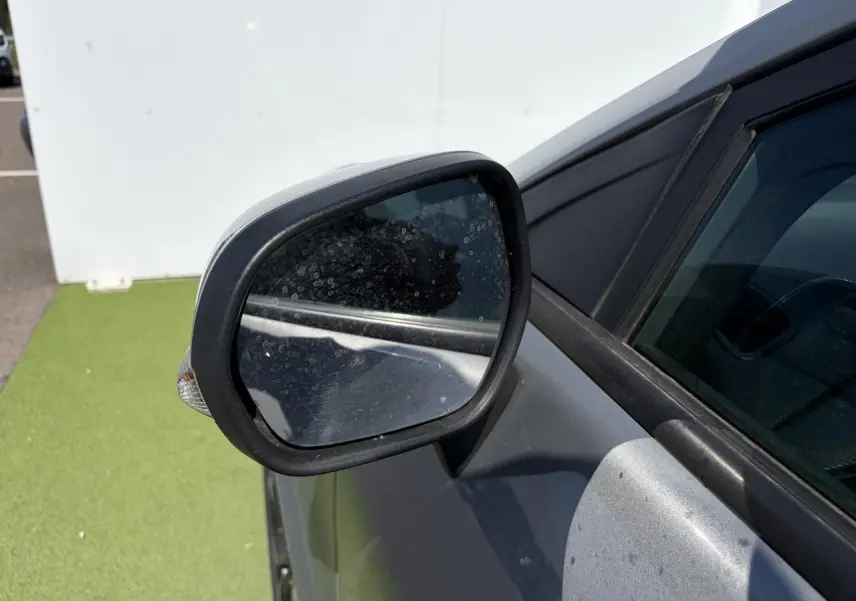 Rétroviseur côté gauche d’un Ford Puma gris métal, avec clignotant intégré et carrosserie visible en arrière-plan.