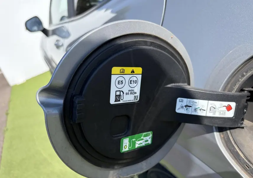 Gros plan sur la trappe à carburant ouverte d’un Ford Puma gris métal, avec consignes de carburant visibles.